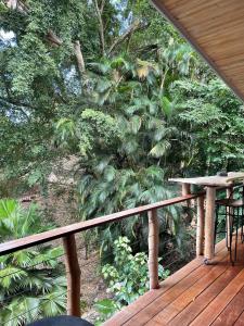 a balcony with a view of a forest at Charming bungalow with sea view facing Marina Taina in Punaauia