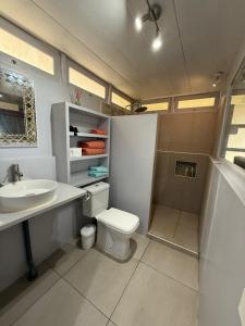 a bathroom with a toilet and a sink at Charming bungalow with sea view facing Marina Taina in Punaauia
