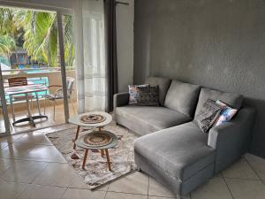 a living room with a couch and a table at Charming Apartment with Pool View Near the Beach in Flic-en-Flac