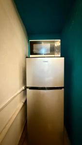 einen Kühlschrank mit einer Mikrowelle darüber in der Unterkunft Brisa Marina Suites - Atras de Playa regatas y Malecon in Veracruz