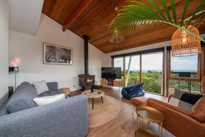 a living room with a couch and a tv at TJ's Tree House with Ocean Views in Cape Schanck