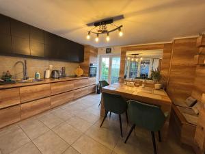a kitchen with wooden cabinets and a table and chairs at Vila Santorini Nacionalni Park Fruška Gora in Rakovac +43 photos
