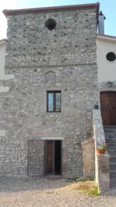 um edifício de pedra com uma porta e uma janela em Country Relais La Torretta Baronale em San Giorgio del Sannio