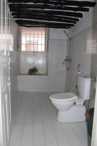 Un baño blanco con inodoro y ventana. en NOMAD Hostel Stone Town, en Zanzíbar 68 fotos más