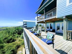 a deck with chairs and tables on a house at Blue Waves - Beachside Calm, Gulf Views for Miles in Freeport