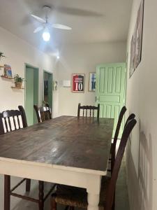 Un comedor con mesa y sillas de madera. en Dragonfly Beach House Quatro Ilhas, en Bombinhas