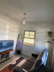 Una sala de estar con un sofá y un televisor de pantalla plana. en Dragonfly Beach House Quatro Ilhas, en Bombinhas