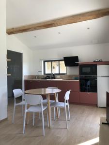 a kitchen with a table and chairs in a room at Maison proche de la Gare TGV in Alixan
