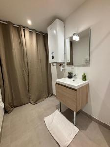 a bathroom with a sink and a mirror at L'Étoile dorée avec Parking in Valence