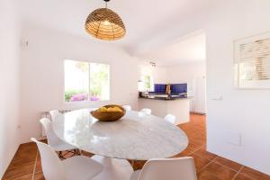 a dining room with a table and white chairs at Can Vishnu in San Jose