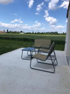 two chairs and a table in front of a field at Maison proche de la Gare TGV in Alixan