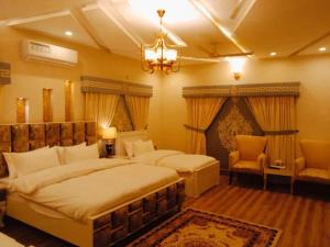 a bedroom with two beds and a chandelier at The Capital Inn in Islamabad
