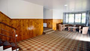 a waiting room with wooden walls and tables and chairs at Pensiunea Curcubeu in Buşteni