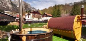 a large hot tub in a yard with houses at Pensiunea Curcubeu in Buşteni