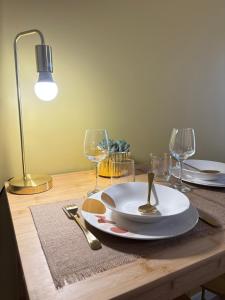 a table with a plate and wine glasses on it at L'Étoile dorée avec Parking in Valence