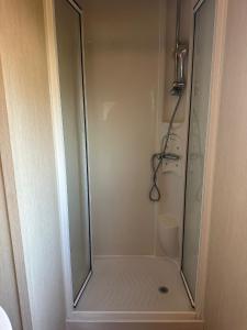 een douche met een glazen deur in een badkamer bij Seawick Caravan 922 in Clacton-on-Sea +18 foto's