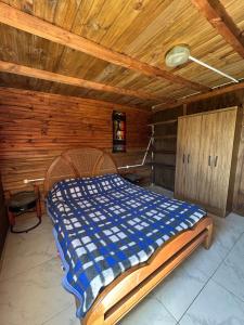 ein Bett in einem Zimmer mit Holzdecke in der Unterkunft El rinconcito del amor pdd in Punta Del Diablo
