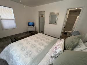 a bedroom with a white bed and a television at Cozy Weekend Retreat! in Wofford Heights