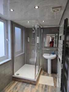 a bathroom with a shower and a sink at IVY- Braveheart Guest House in Edinburgh