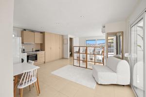 a living room with a white couch and a kitchen at Apt 1' From The Sea With Private Terrace & BBQ in Vari