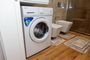 a washing machine in a bathroom with a toilet at Lux Holidays 221 in Durrës +15 photos