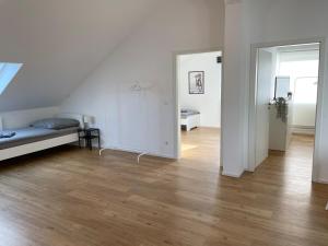 a white room with a bed and a wooden floor at 2 bedroom apartment with 4 beds in Pfaffenhofen PAF01 in Pfaffenhofen