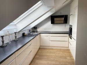 a kitchen with white cabinets and a black counter top at 2 bedroom apartment with 4 beds in Pfaffenhofen PAF01 in Pfaffenhofen
