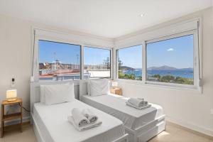 two beds in a white room with windows at Apt 1' From The Sea With Private Terrace & BBQ in Vari