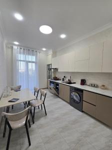 a kitchen with a table and chairs and a tableasteryasteryasteryasteryasteryastery at Conveniently located near the Tashkent City area, close to the city center in Tashkent
