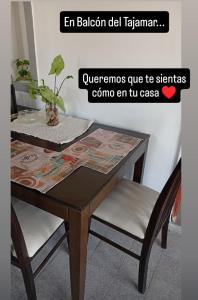 a wooden table with two chairs and a plant on it at Balcón al Tajamar in Alta Gracia