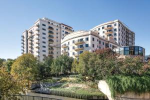 twee hoge gebouwen naast een rivier met bomen bij Club Wyndham La Cascada in San Antonio