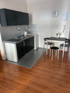 een keuken met een spoelbak en een tafel met stoelen bij 1 st may plaza de luxe in Bratislava