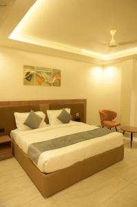 a bedroom with a large bed and a chair at Diesel inn hotel in Hanumāngarh