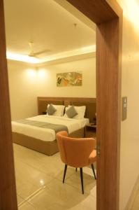 a bedroom with a bed and a chair at Diesel inn hotel in Hanumāngarh