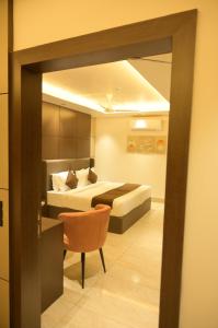 a hotel room with a bed and a chair at Diesel inn hotel in Hanumāngarh +3 photos