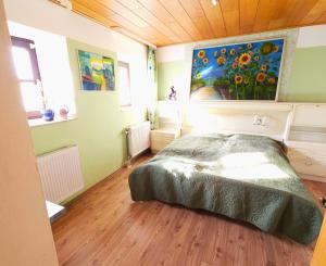a bedroom with a bed and a painting on the wall at Ferienwohnung an der Altmühl - Apartment Hollerstein in Pappenheim