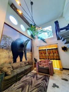 a living room with a couch and a picture of an elephant at Recanto Rustico Itapoá in Itapoa