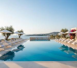 a hotel swimming pool with chairs and umbrellas at THE PERLA Bodrum HOTEL in Bodrum City