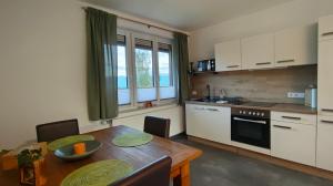 a kitchen with a wooden table and a dining room at Appartment Herzblick in Sankt Georgen im Gailtal