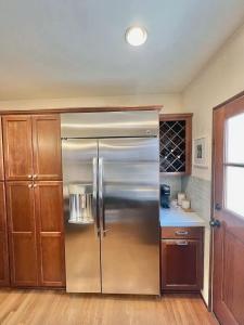 eine Küche mit Edelstahlkühlschrank und Holzschränken in der Unterkunft Three Bedroom Home in Long Beach in Belmont Shore
