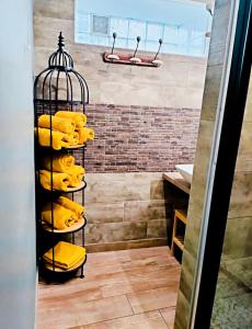 Un estante con toallas amarillas en un baño. en chambre Carla gite le loft bleu, en Sablons