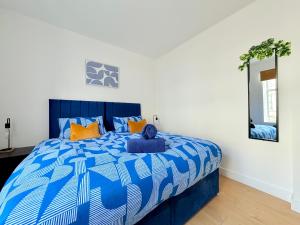 een blauw en wit bed in een kamer met een spiegel bij Spacious Preston Circus Flat - Great for Family, Group, Couples - Close to Station in Brighton & Hove
