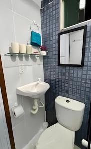 a bathroom with a toilet and a sink and a mirror at Flat em Maracaípe -Praia vizinha Porto de Galinhas in Porto De Galinhas