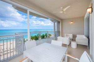 a white dining room with a view of the ocean at Beachcomber 27 in George Town