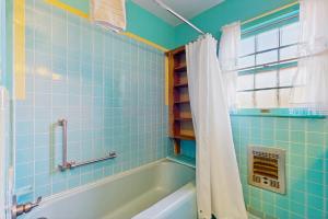 a blue tiled bathroom with a tub and a window at Angels Rest in Fredericksburg +12 photos