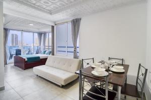 a living room with a dining table and a bed at Maralago el Conquistador Apartamentos Cartagena in Cartagena de Indias