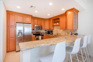a kitchen with wooden cabinets and stainless steel appliances at Beachcomber 27 in George Town +19 photos