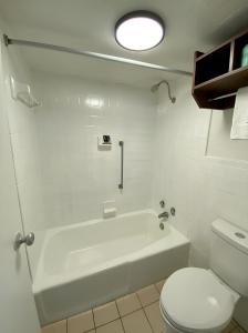 a white bathroom with a tub and a toilet at My Home at Columbus in Columbus