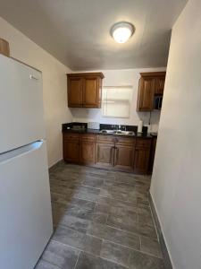 a kitchen with wooden cabinets and a white refrigerator at Cozy Weekend Retreat! in Wofford Heights