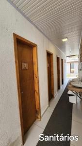 a row of doors in a hallway with a sink at Hostel Costa Terral in Matinhos